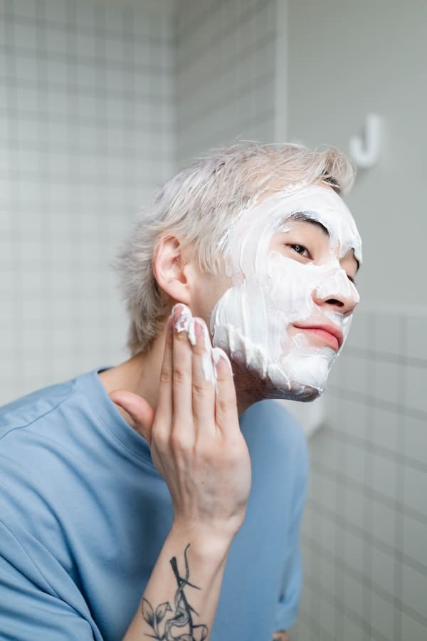 male washing face with cleanser