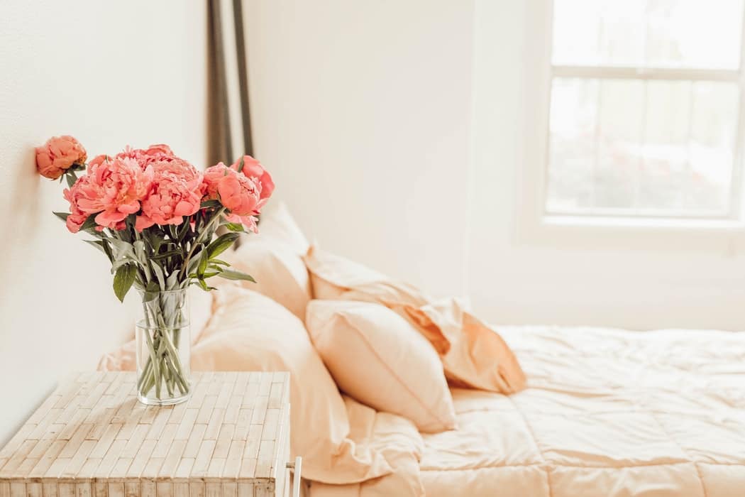 bed with flowers on nightstand