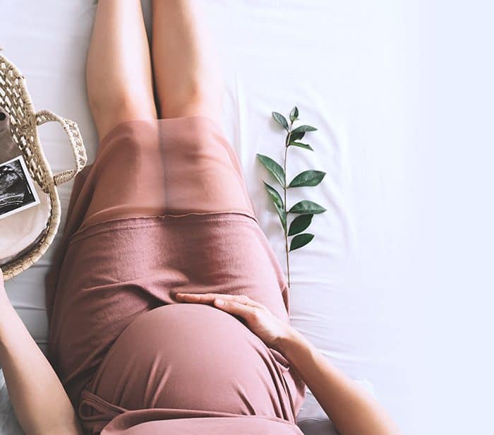 pregnant woman holding ultrasound photo