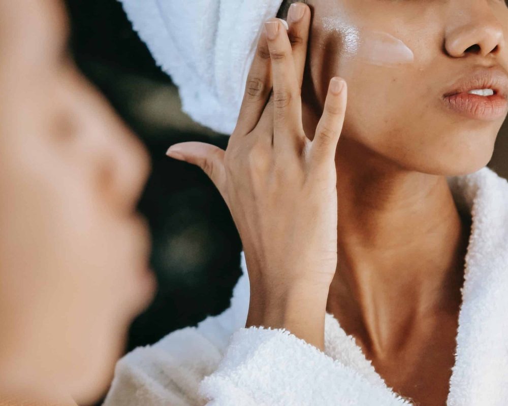 model applying skincare on cheek